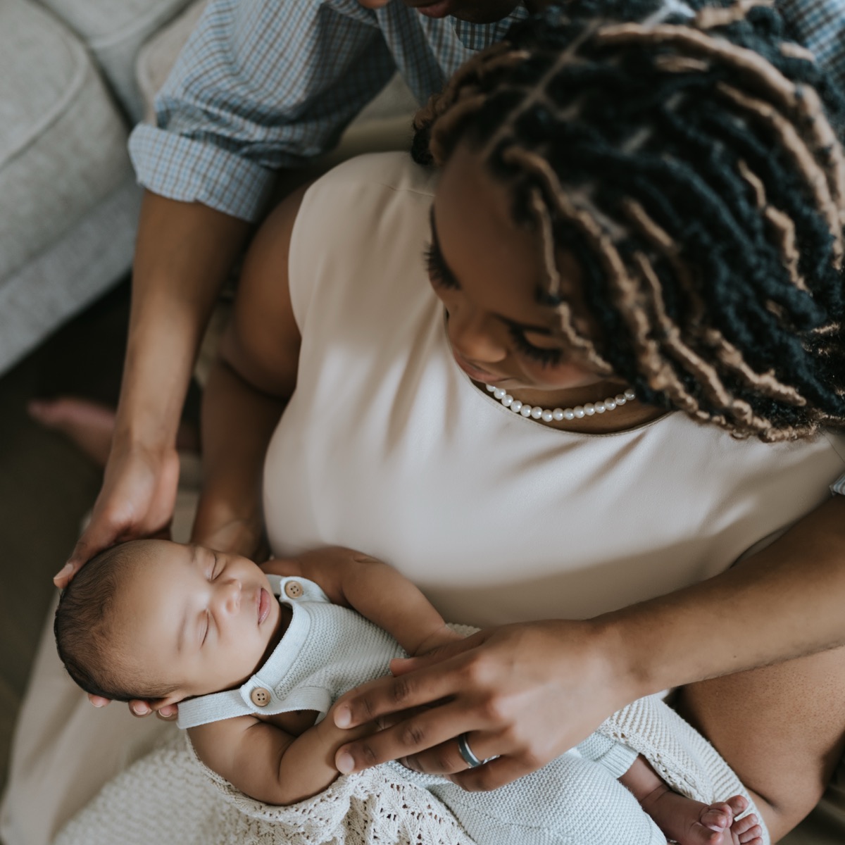 Close-up of mother gazing down at peacefully sleeping Yohannes cradled in both parents' arms