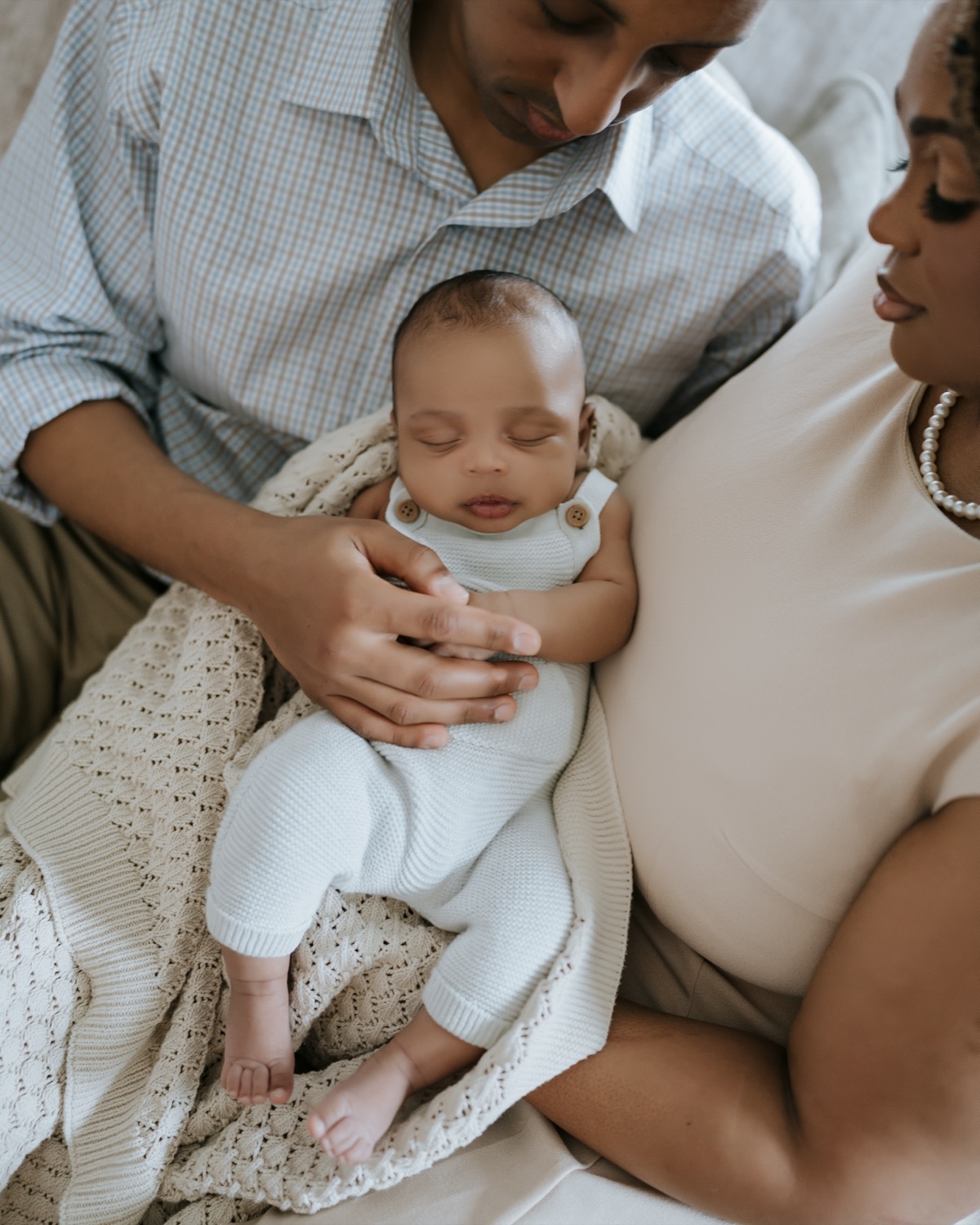 Close-up of father cradling sleeping Yohannes while mother looks on tenderly from beside them